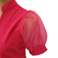 pink blouse with sheer sleeves on a mannequin against a white background