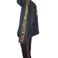 Black outfit with gold sequin stripes on a mannequin against a white background