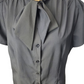 black blouse with a tie collar on a mannequin against a white background