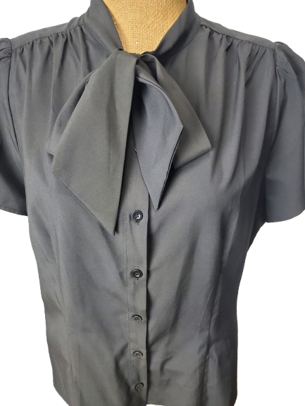 black blouse with a tie collar on a mannequin against a white background