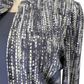 Patterned scarf draped over a mannequin on a white background