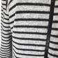 Close-up of a black and gray striped sweater with a zipper.