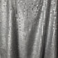 Close-up of silver sequin fabric with a black background