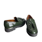 Pair of green loafers with tassels on a white background