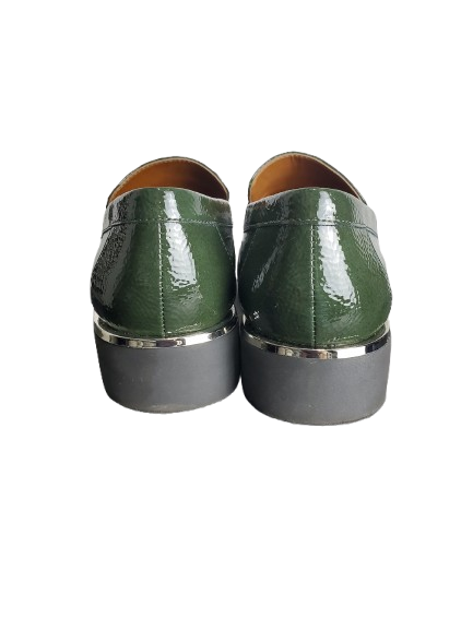 Pair of green shoes with gray soles on a white background