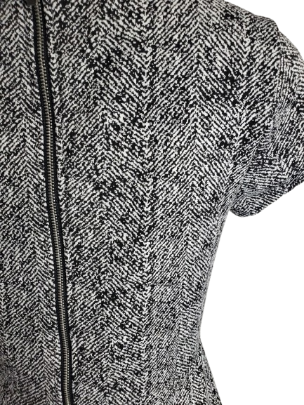 Close-up of a textured black and white garment with a zipper.
