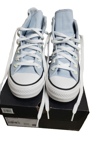 Light blue sneakers with white laces on a black box against a white background