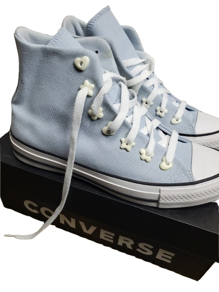 Light blue high-top sneakers with white laces on a black Converse box.
