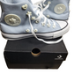 Light blue Converse high-top sneakers with white laces on a black Converse box.