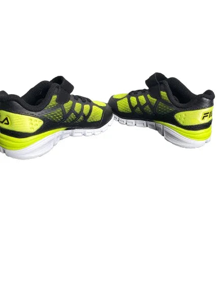 Pair of black and neon green running shoes on a white background