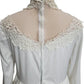 White lace-trimmed blouse on a mannequin with a white background