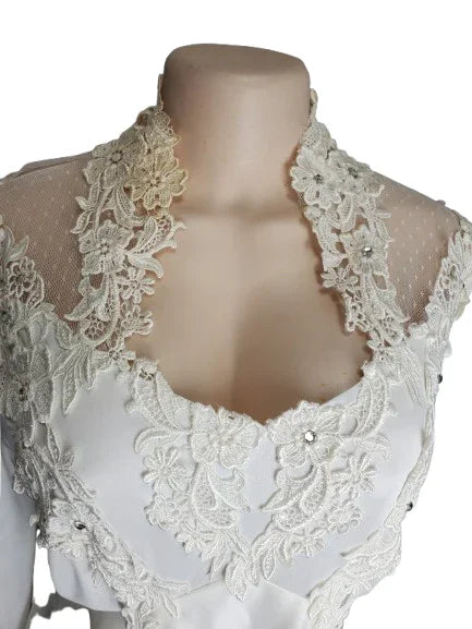 White lace top on a mannequin with a plain background