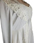 White dress with lace detailing on a white background