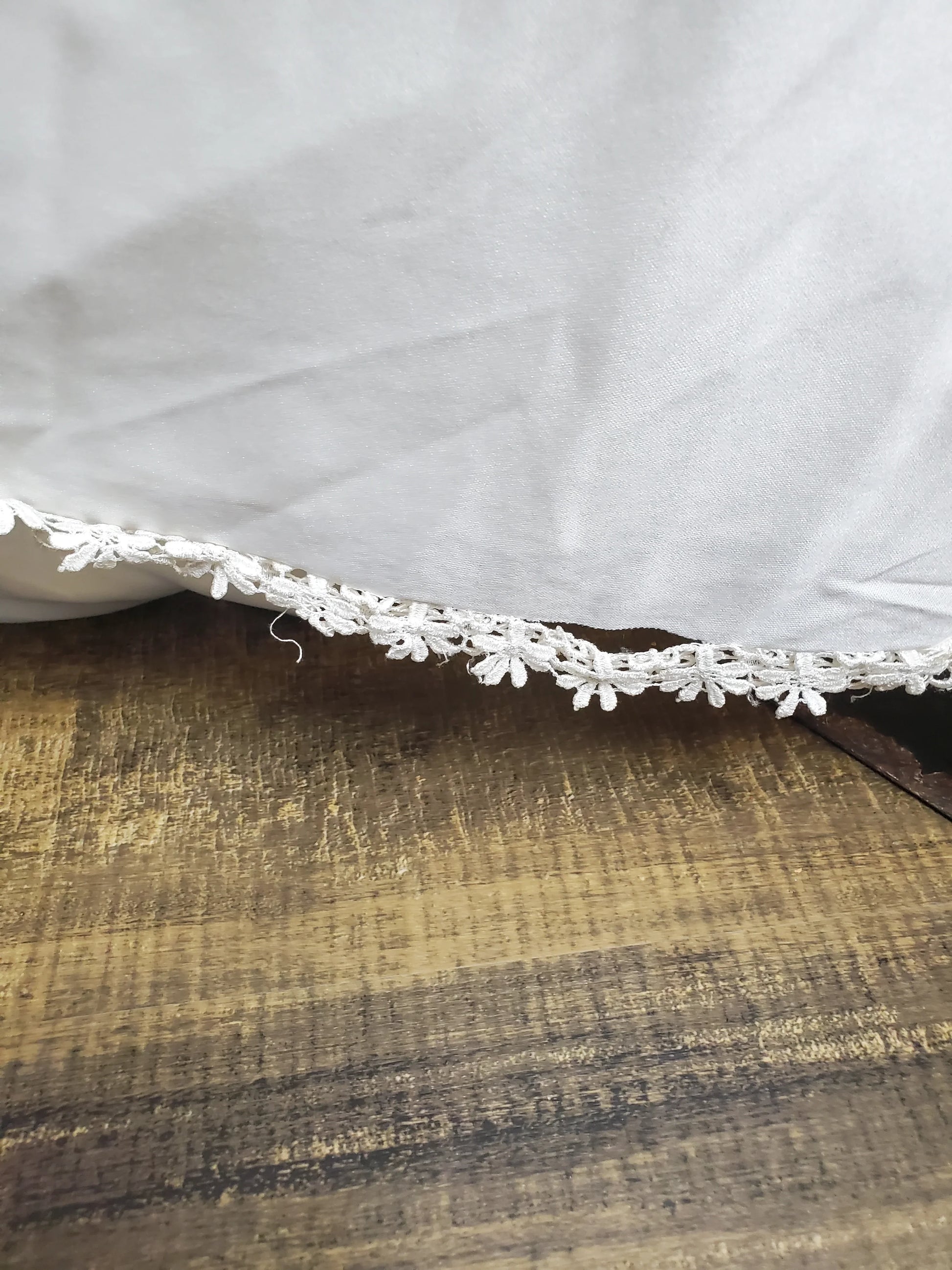 Close-up of a white lace trim on a wooden surface
