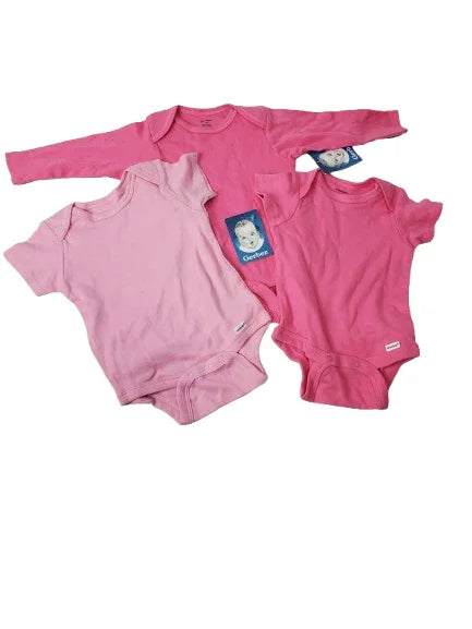 Pink baby onesies with tags on a white background