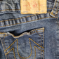 Close-up of True Religion jeans with a focus on the brand label and pocket design.