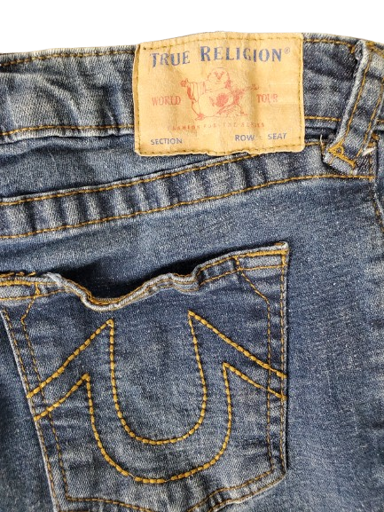 Close-up of True Religion jeans with a focus on the brand label and pocket design.