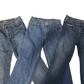 Three pairs of blue jeans stacked on a white background