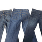 Three pairs of blue jeans stacked on top of each other against a white background