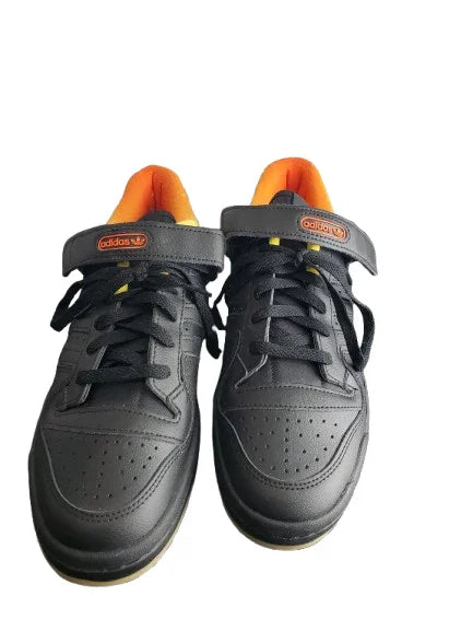 Black sneakers with orange accents on a white background