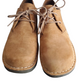 Pair of tan leather shoes with laces on a white background