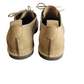 Pair of tan suede shoes on a white background
