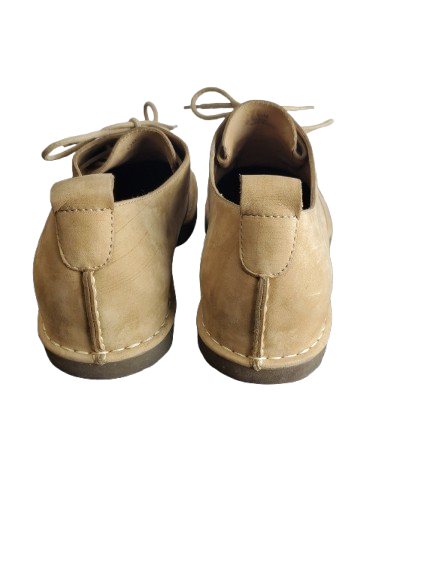 Pair of tan suede shoes on a white background