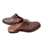 Pair of brown leather clogs on a white background