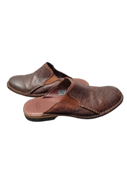 Pair of brown leather clogs on a white background