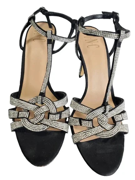 Black high-heeled shoes with silver embellishments on a white background