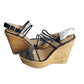 Pair of cork wedge sandals with clear straps on a white background
