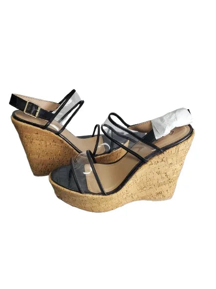 Pair of cork wedge sandals with clear straps on a white background