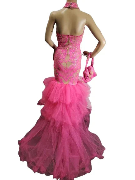 Mannequin wearing a pink evening gown with a matching handbag on a white background