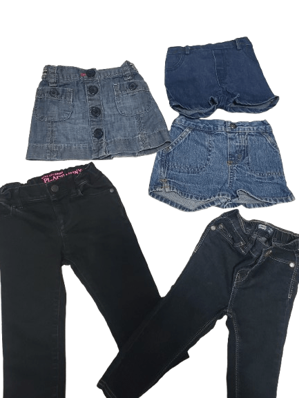 Folded blue jeans and black pants on a white background