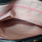 Close-up of a pink textured fabric interior with visible stitching.