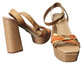 Pair of high-heeled sandals with woven design on a white background