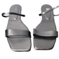 Pair of black sandals with thin straps on a white background