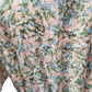 Close-up of a floral patterned fabric with pink, blue, and green colors.