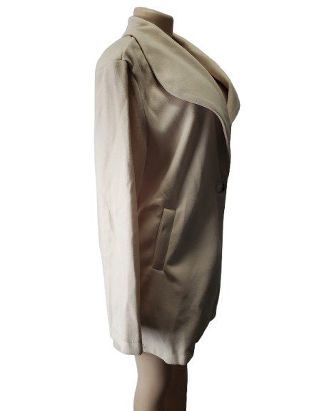 Mannequin wearing a beige draped garment on a white background