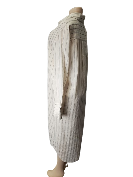 Mannequin wearing a long, striped dress with a white background