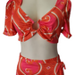 Orange and pink patterned top and skirt set on a mannequin against a white background