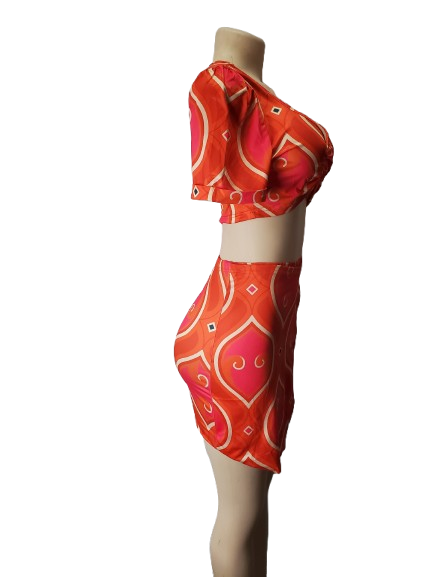 orange patterned two-piece outfit on a mannequin against a white background