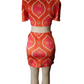 Mannequin wearing a  orange and pink patterned outfit on a white background