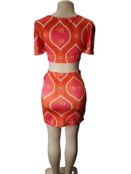 Mannequin wearing a  orange and pink patterned outfit on a white background