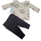 Children's outfit with heart-patterned shirt and dark pants on a white background
