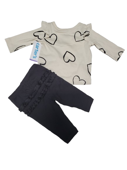 Children's outfit with heart-patterned shirt and dark pants on a white background