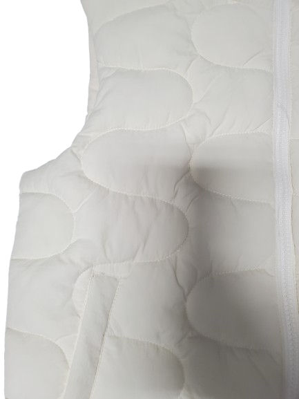 Close-up of a white quilted mattress with circular patterns on a white background