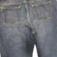Close-up of blue jeans with back pocket details on a white background