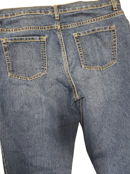 Close-up of blue jeans with back pocket details on a white background