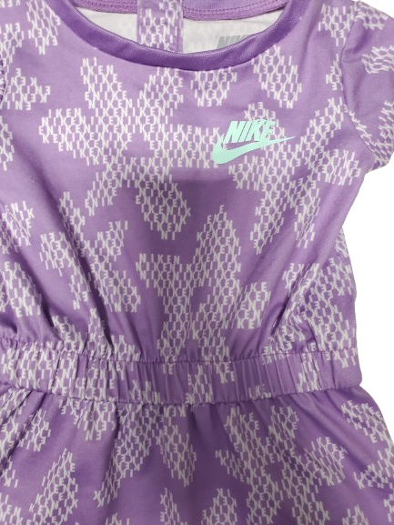 Purple athletic romper with white pattern and green logo on a white background